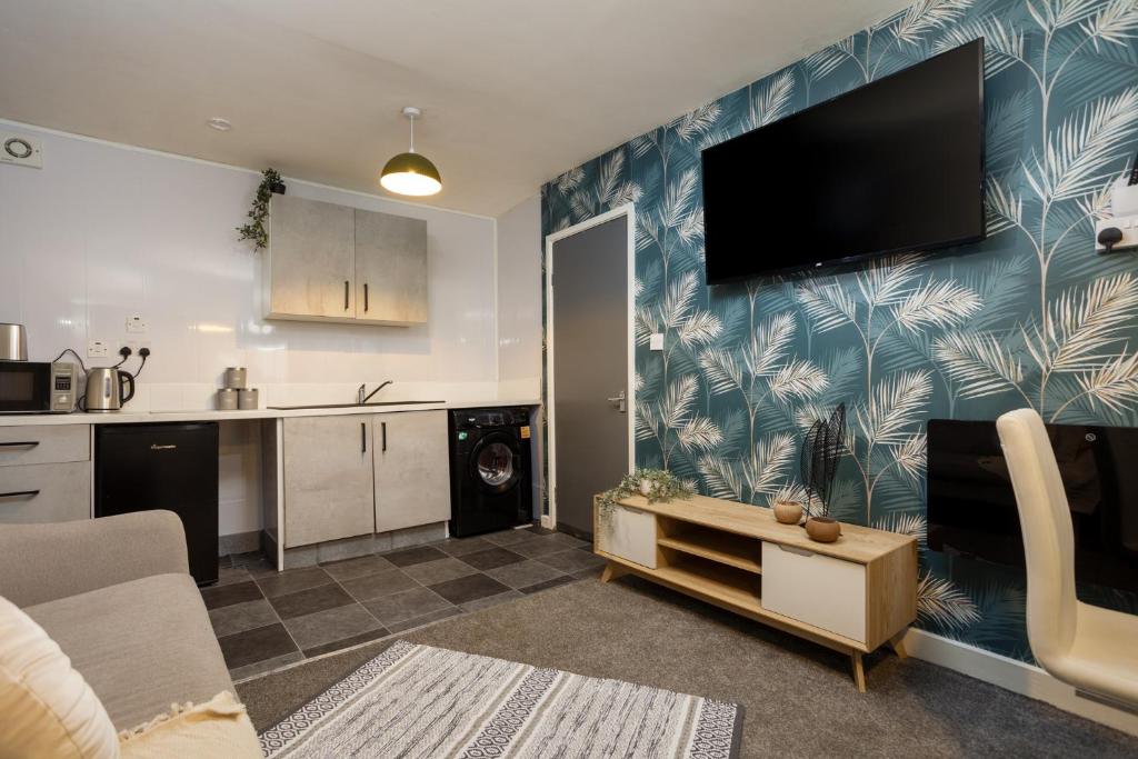 a living room with a flat screen tv on a wall at Lovely Getaway Apartment: Two-Bedroom in Rotherham in Rotherham