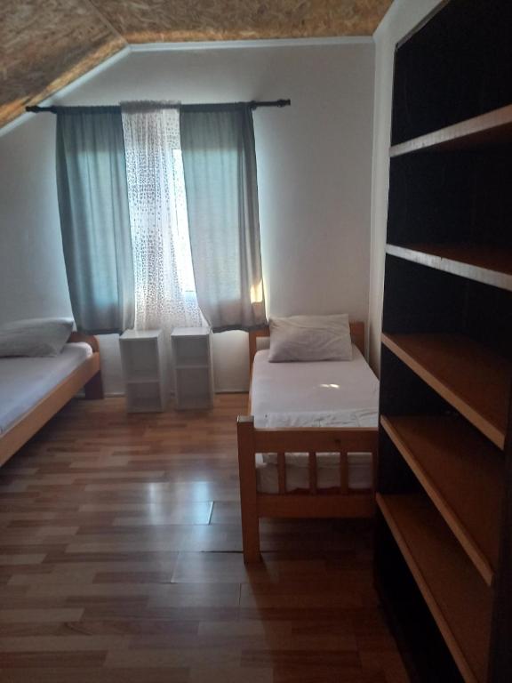 Habitación pequeña con cama y ventana en Hostel Dragana, en Podgorica