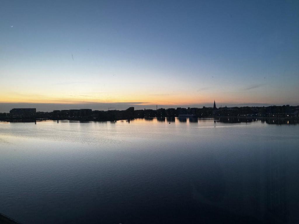 Blick auf einen großen Wasserkörper bei Sonnenuntergang in der Unterkunft Strand-Apartment, Strandkorb, Meeresrauschen, Parkplatz in Wilhelmshaven