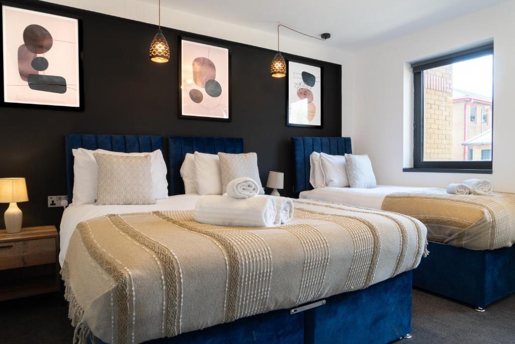 2 camas en una habitación con paredes negras en Apartment by DH ApartHotels en Peterborough