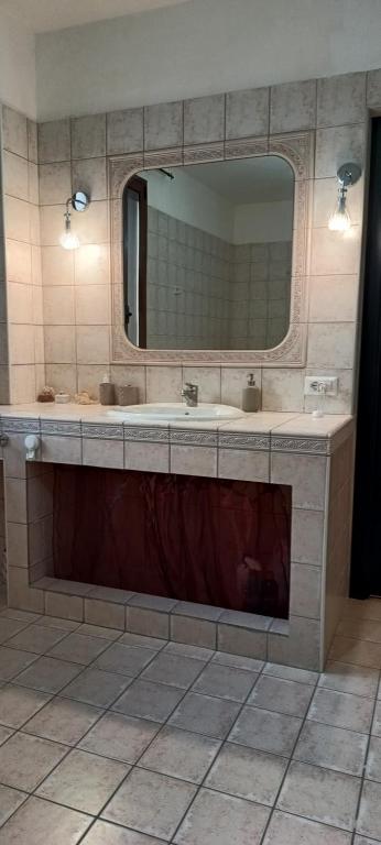 a bathroom with two sinks and a large mirror at Le Residenze di Niso in Syracuse