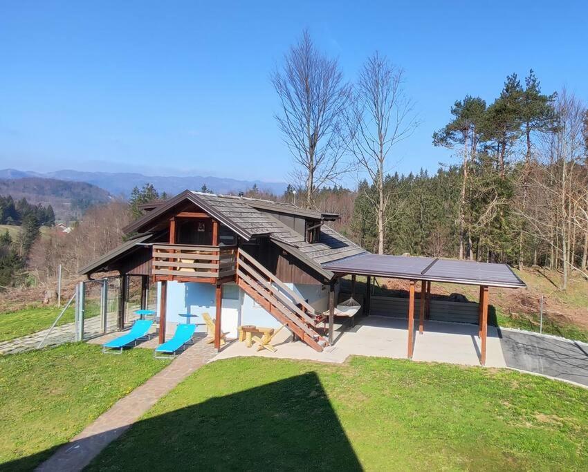 ein großes Haus mit einer Terrasse und einem Spielplatz in der Unterkunft Počitniška hiška v gozdnem raju in Trebče