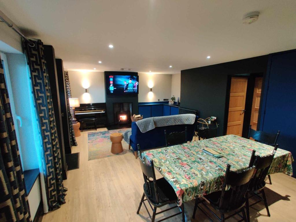 a living room with a table and a tv at Harmony Cottage in Eglinton