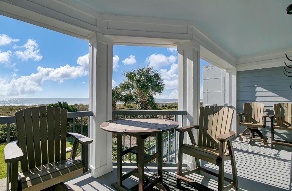 a porch with a table and chairs and a view of the ocean at Ocean Blvd 102 Beautiful Condo with Ocean Views in Isle of Palms