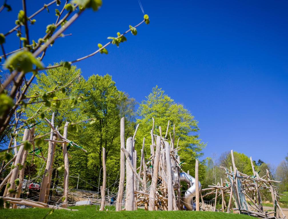 uma pilha de troncos num campo com árvores em Ferienpark Geyersberg em Freyung