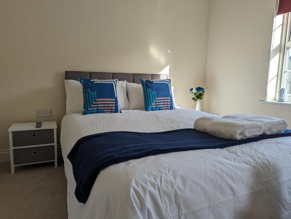 a bedroom with a large bed with blue and white pillows at 83 in Bournemouth