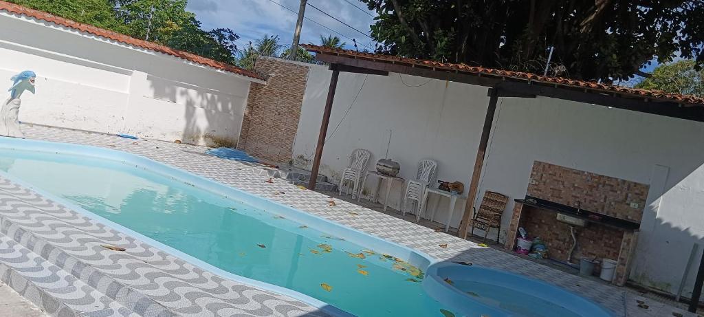 uma piscina com duas cadeiras ao lado de uma casa em Casa de praia no sossego em Ponta do Funil