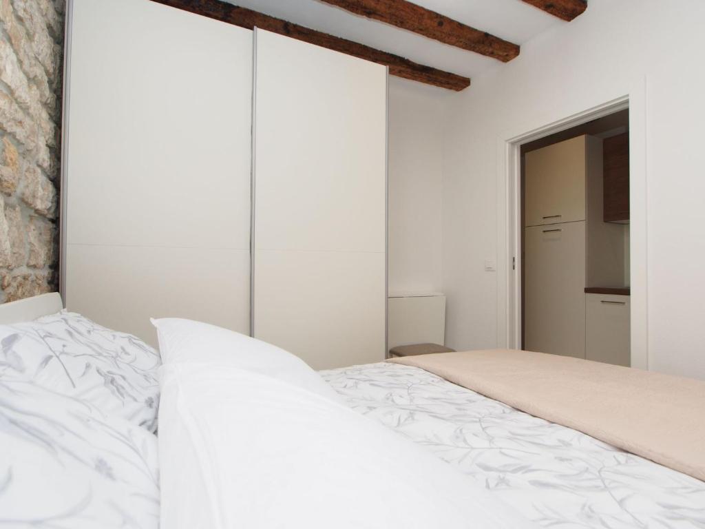 Schlafzimmer mit weißen Wänden und einem Bett in der Unterkunft Apartman 4* Ester in Rovinj