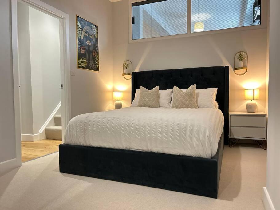 een slaapkamer met een bed met een zwart hoofdeinde en een raam bij Trendy City Centre Apartment with FREE Parking in Southampton