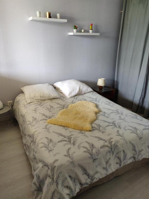 a bed with a yellow blanket on it in a bedroom at 2 chambres dans maison familiale in Le Passage
