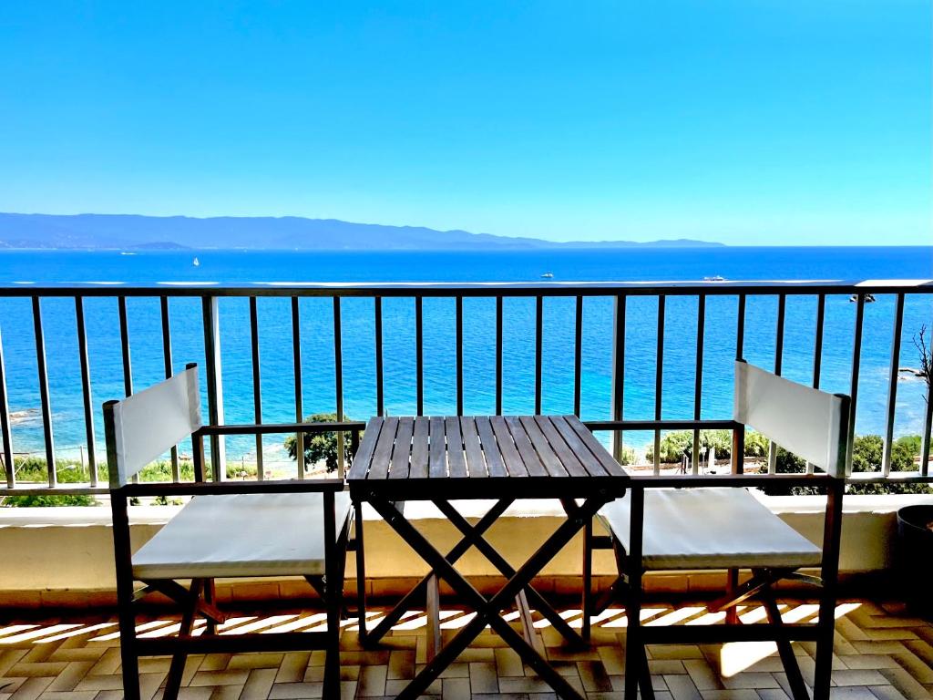 une table et des chaises sur un balcon avec l'océan dans l'établissement Appartement avec magnifique vue mer, à Ajaccio