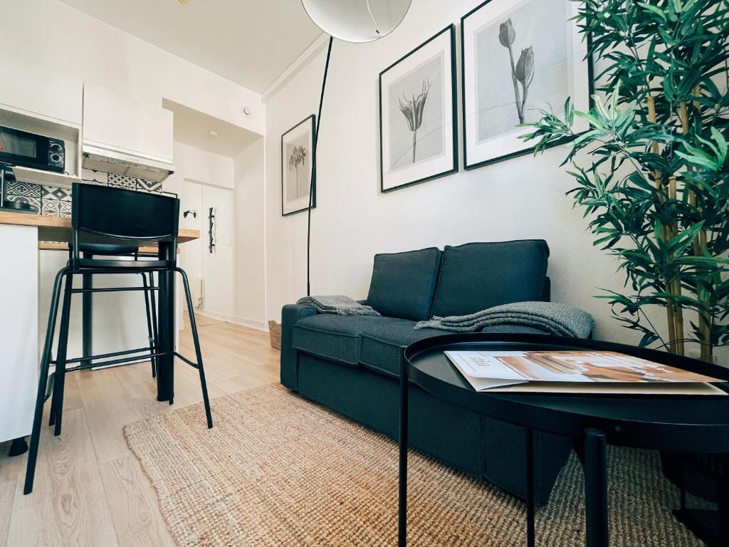 ein Wohnzimmer mit einem grünen Sofa und einem Tisch in der Unterkunft Respire Bordeaux in Bordeaux