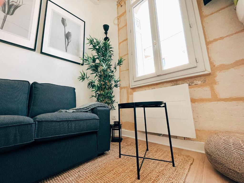 ein Wohnzimmer mit einem Sofa und einem Tisch in der Unterkunft Respire Bordeaux in Bordeaux
