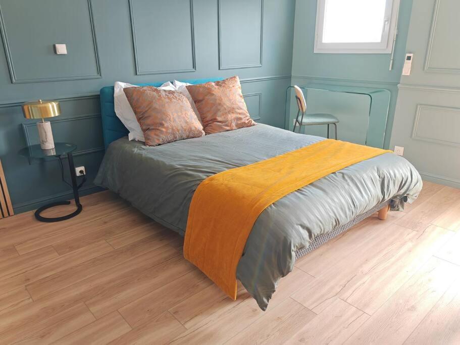 une chambre avec un lit aux murs bleus dans l'établissement Appartement cosy climatisé, à La Rochelle