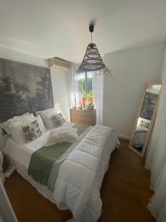 Un dormitorio con una cama grande y una ventana en Bel appartement en résidence avec 3 piscines, en Mandelieu-la-Napoule