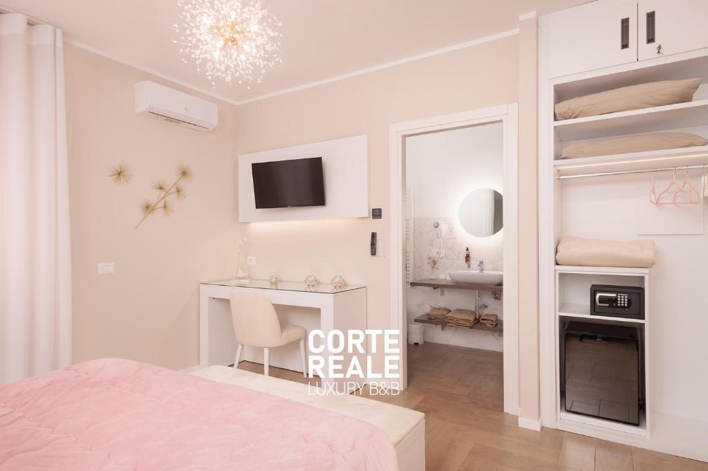 a white bedroom with a bed and a desk at CORTE REALE Luxury B&B in San Salvo