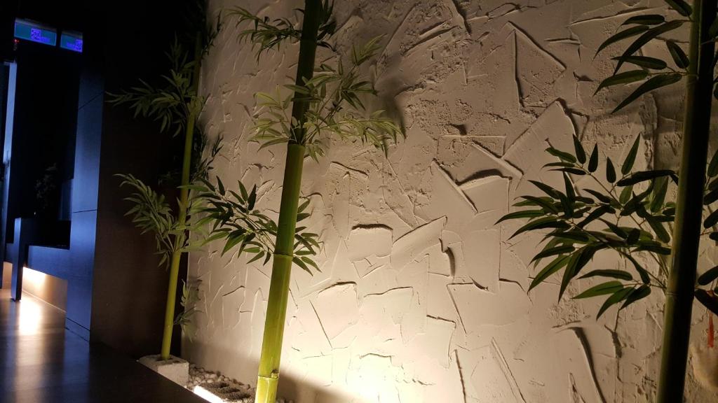 a wall with some plants and graffiti on it at Yang Home Stay in Ruisui