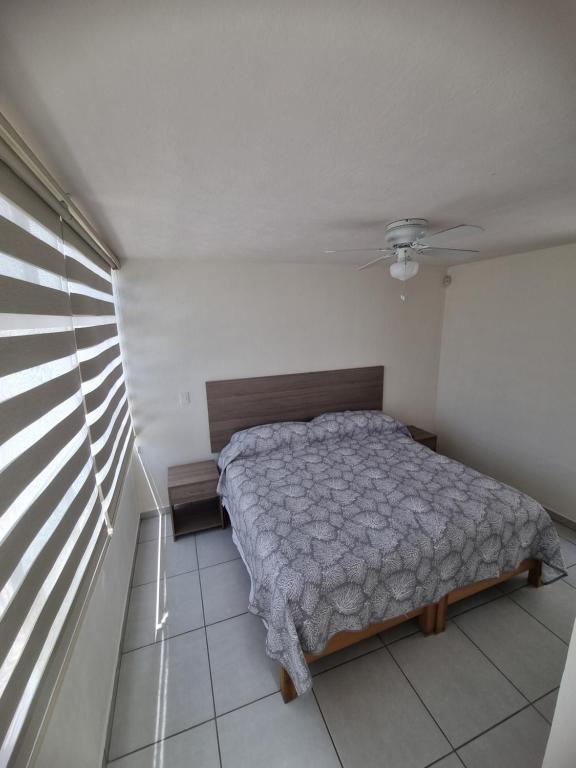 1 dormitorio con cama y ventana en Casa Denali en Aguascalientes