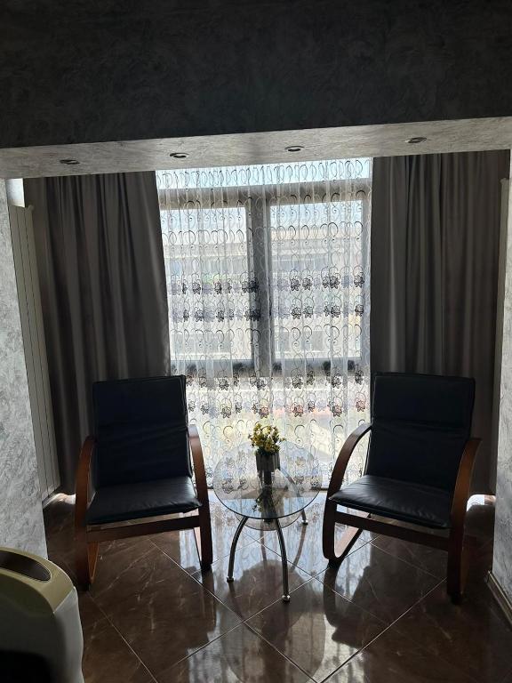 two chairs and a glass table in front of a window at Nicoreb apartament in Brăila