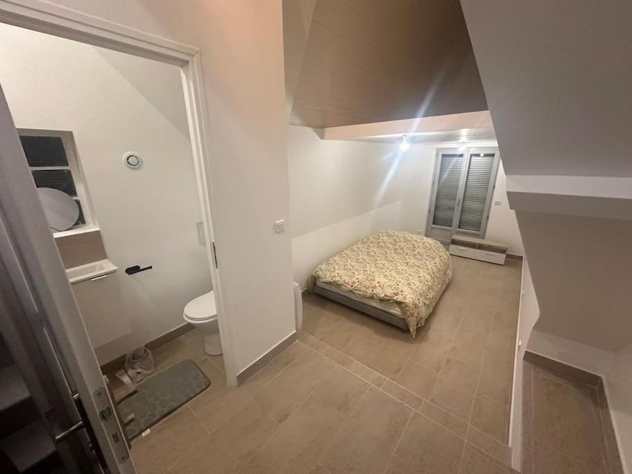 Kleines Zimmer mit einem Bett und einem WC in der Unterkunft Studio dans une maison 2/3 in Aulnay-sous-Bois