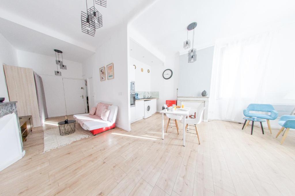 ein weißes Wohnzimmer mit einem Tisch und Stühlen in der Unterkunft T2 à 5 min de la GARE , CENTRALE et LUMINEUX in Marseille