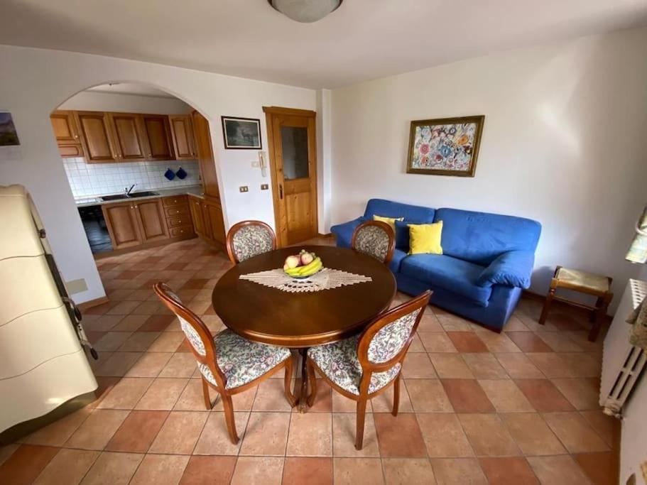 salon ze stołem i niebieską kanapą w obiekcie Appartamento da Romano - nel cuore delle Dolomiti w mieście Danta
