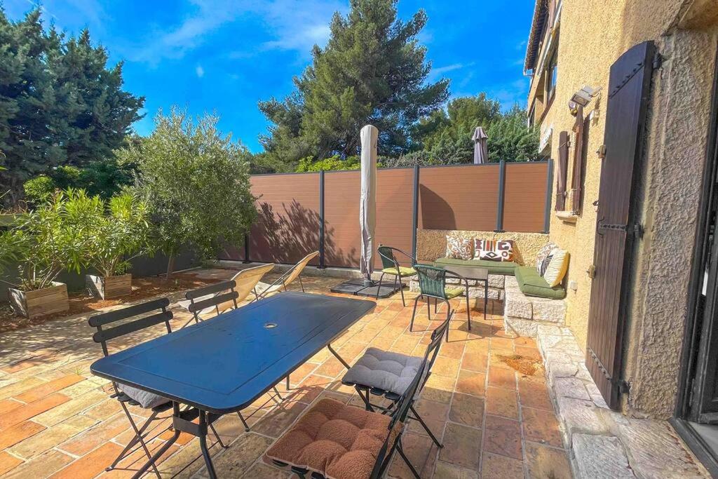 d'une terrasse en briques avec une table et des chaises. dans l'établissement L'Olivier - Clim - Terrasse, à Cassis