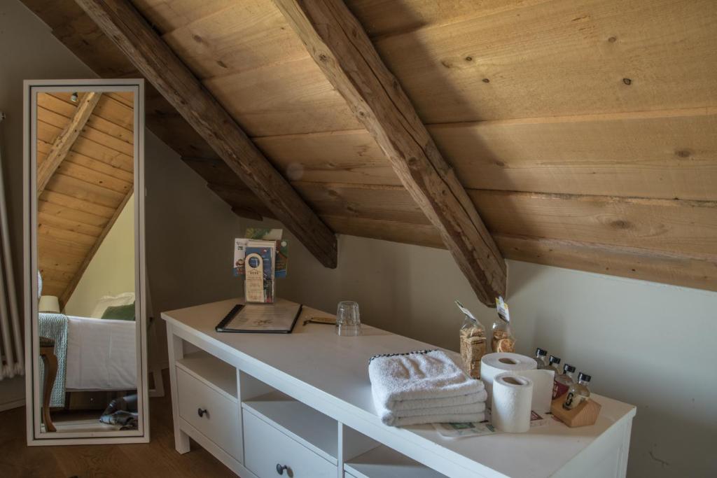 Habitación con tocador blanco y espejo. en Le Paysan Horloger en Les Bois