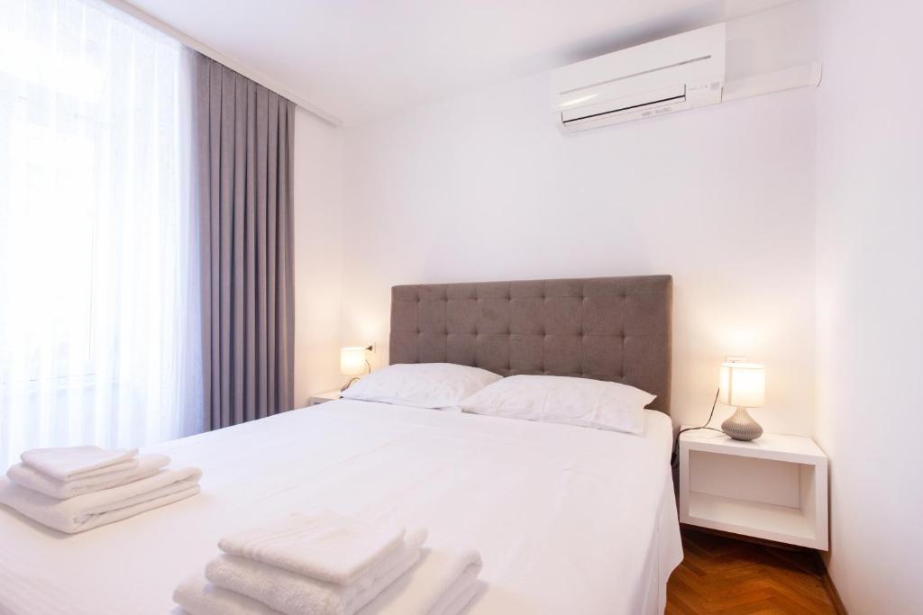 a bedroom with a white bed with white towels on it at Apartmaji pri Perotu in Izola