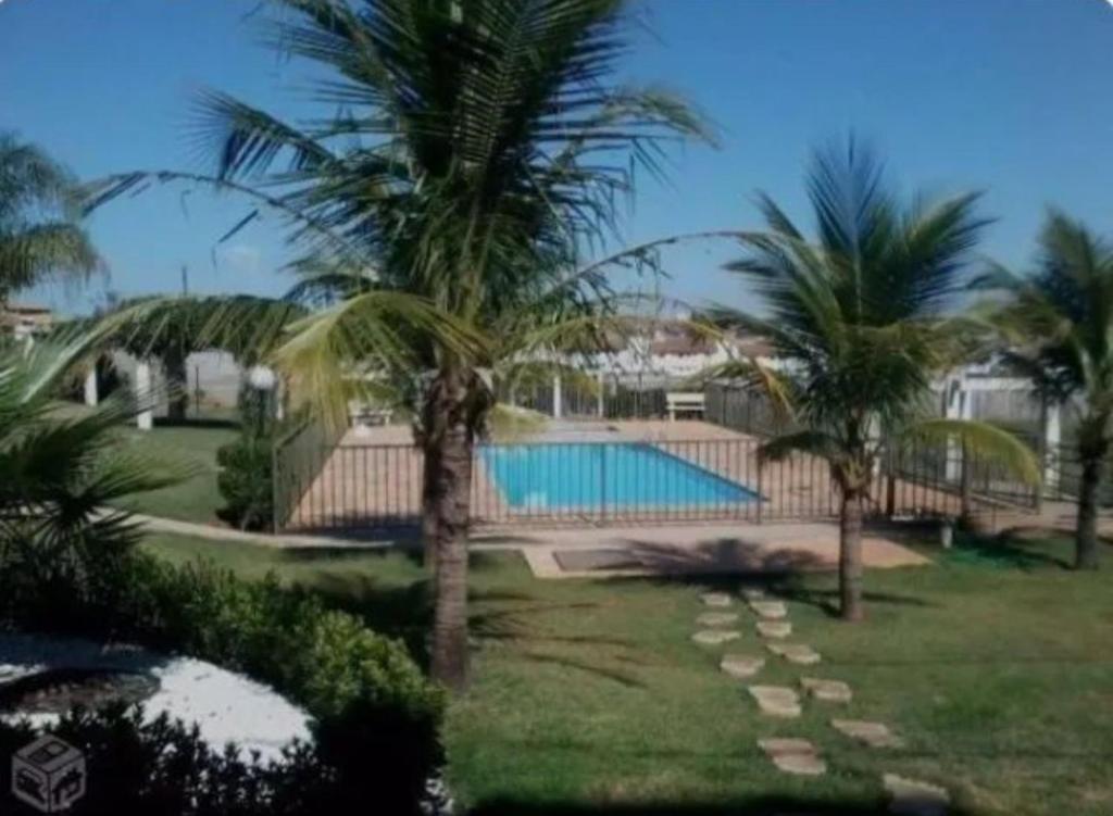 a resort with a swimming pool and palm trees at Quarto suíte represa centro, ape compartilhado in Sao Jose do Rio Preto