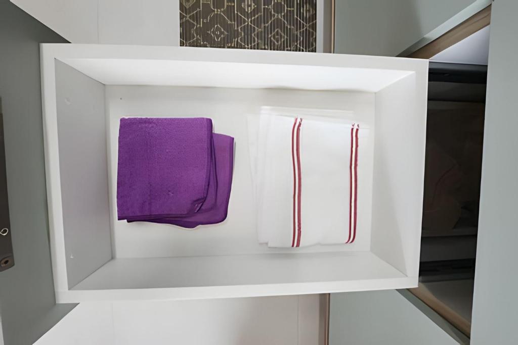 a white cabinet with a purple napkin in it at Conforto no Caminho das árvores in Salvador