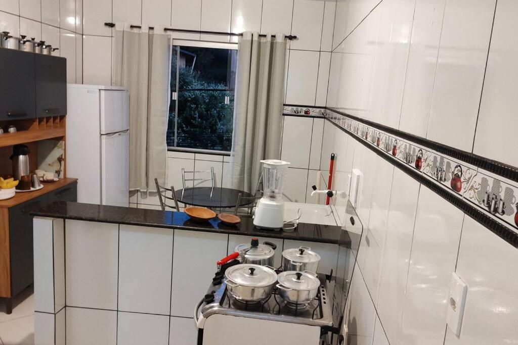 uma cozinha com um fogão com panelas e frigideiras em Acomodação paraju-apartamento em caratinga em Caratinga