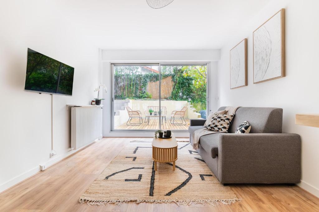 un salon avec un canapé et une table dans l'établissement Flat Rue d'Assas private garden, à Paris