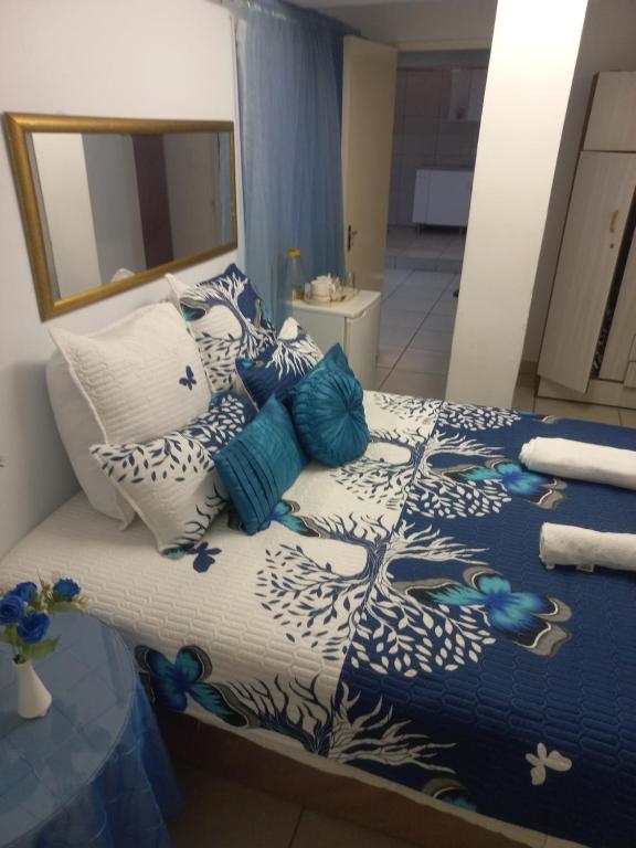 - une chambre avec un lit doté d'oreillers bleus et blancs dans l'établissement Triple T Guest house, à Johannesbourg