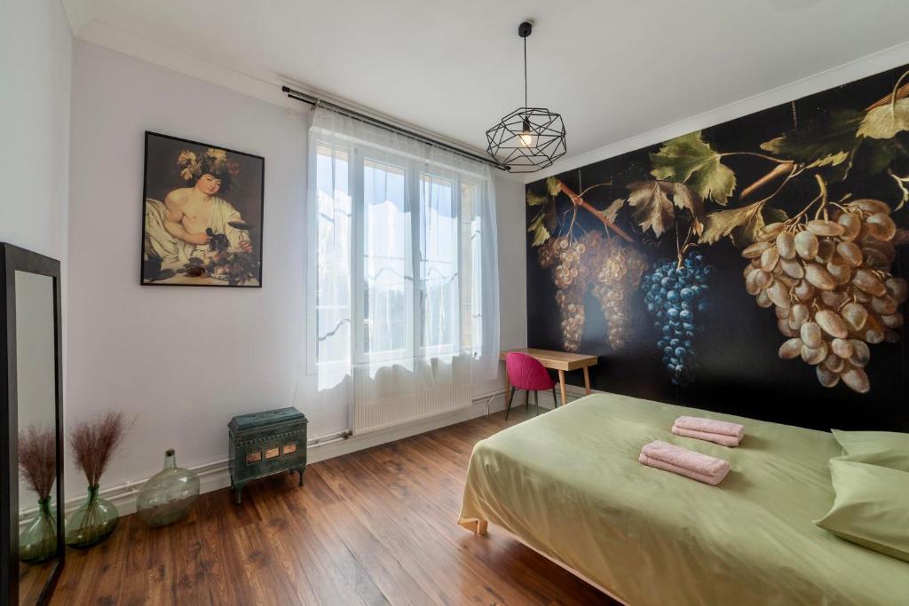 a bedroom with a bed and a painting on the wall at La maison Grand Cru in Arveyres
