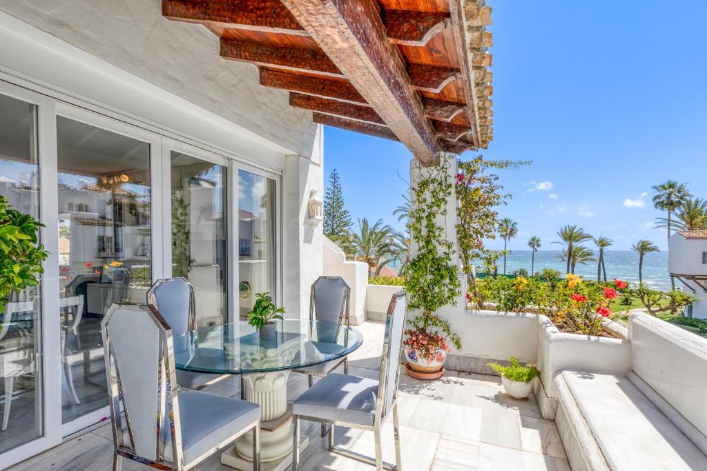 a patio with a glass table and chairs at Hanami Alcazaba Beach Duplex Sea View in Estepona