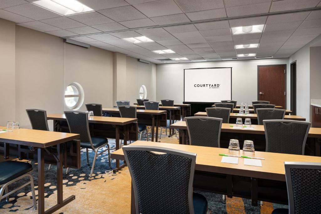 a conference room with tables and chairs and a whiteboard at Courtyard Seattle Downtown / Pioneer Square in Seattle