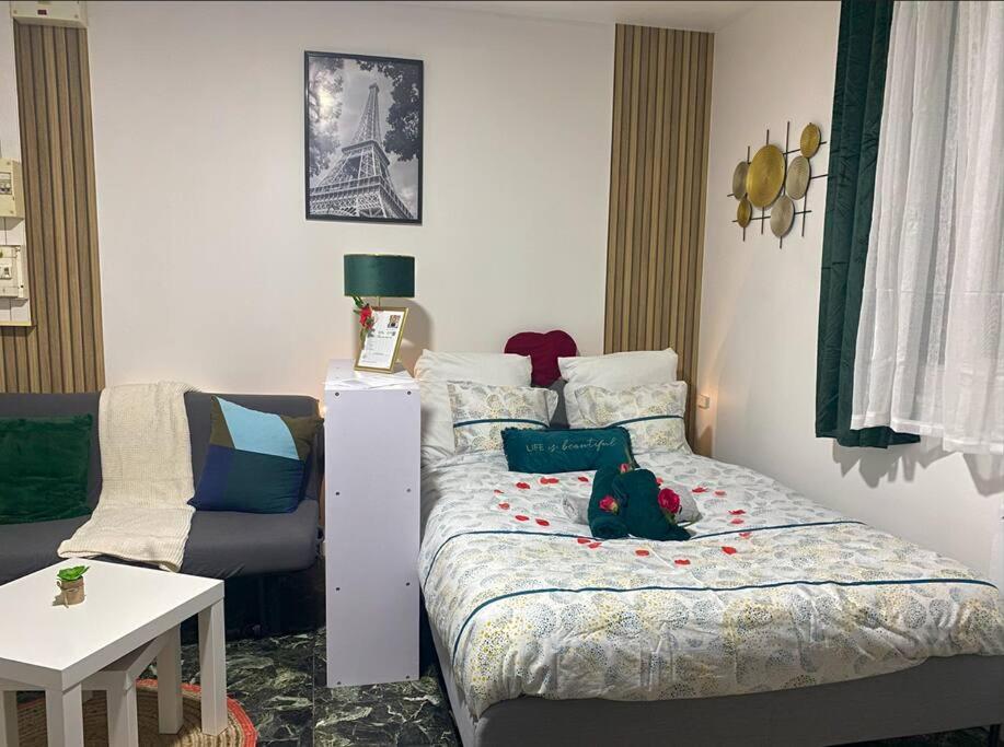 ein kleines Schlafzimmer mit einem Bett und einem Sofa in der Unterkunft Le Mini SweetHome - Bobigny- Porte de Paris in Bobigny