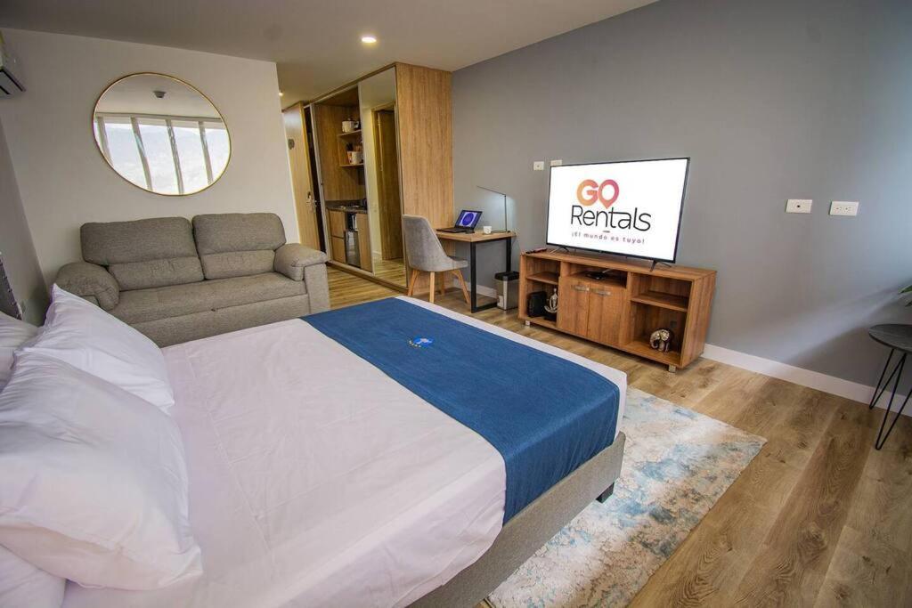 une chambre avec un lit et une télévision à écran plat dans l'établissement TOP FLOOR Studio Poblado, A/C, Coworking, gym 1416, à Medellín