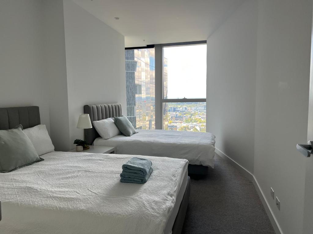 メルボルンにあるWSP LUX 1B1B apartment in CBDのベッドが2つと窓がある白い部屋