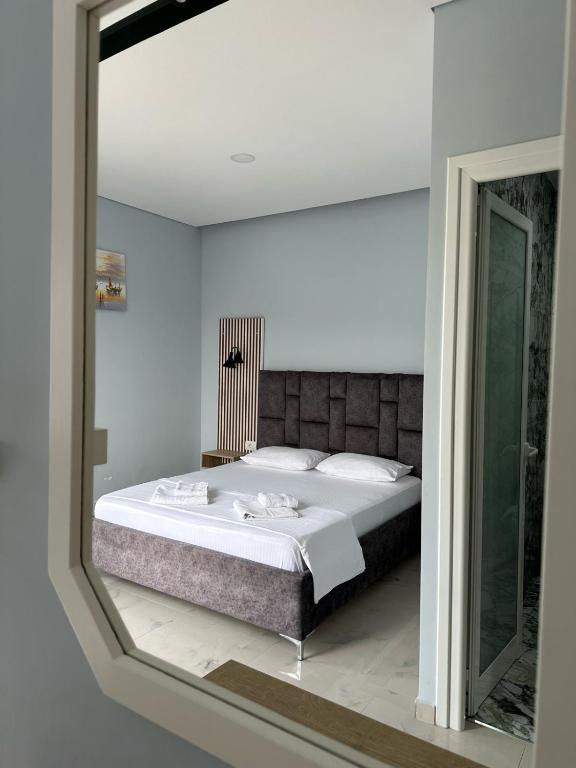 a bedroom with a large bed and a mirror at Summer Gate Hotel in Ksamil