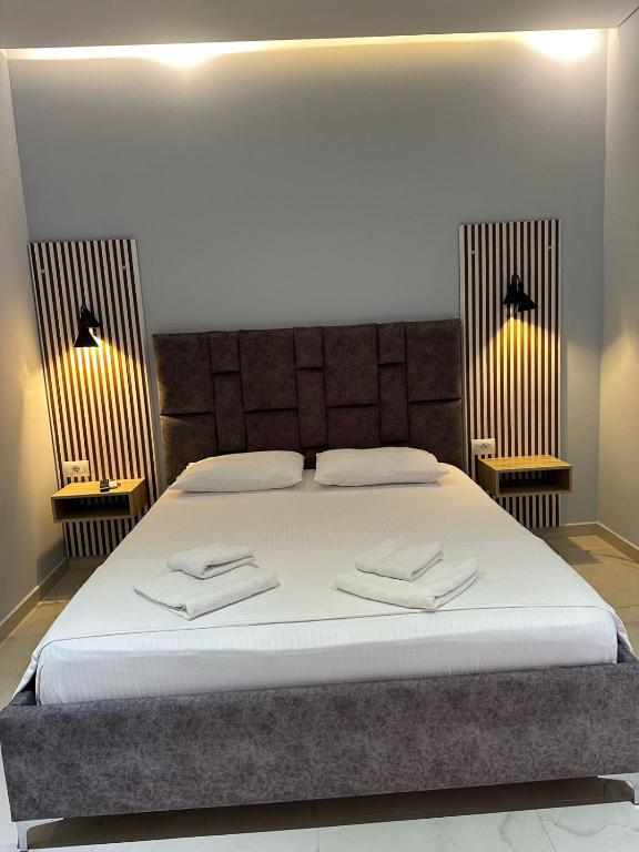 a bedroom with a bed with two towels on it at Summer Gate Hotel in Ksamil
