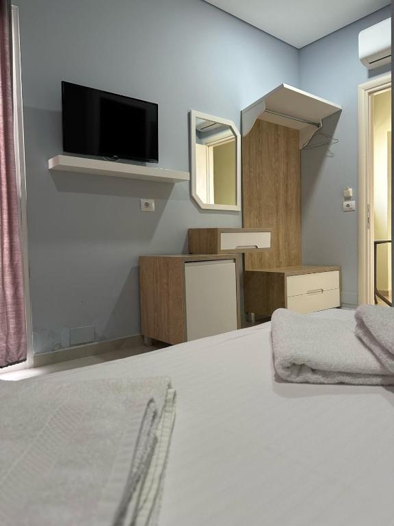 a room with a bed with a tv and a mirror at Summer Gate Hotel in Ksamil