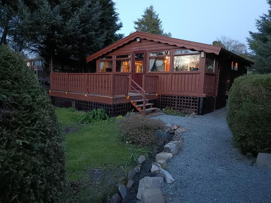 a large wooden cabin with a large window at 299 Willow Lodge in Trawsfynydd