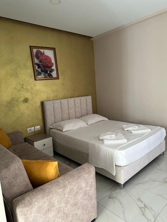 a bedroom with a large bed and a couch at Summer Gate Hotel in Ksamil