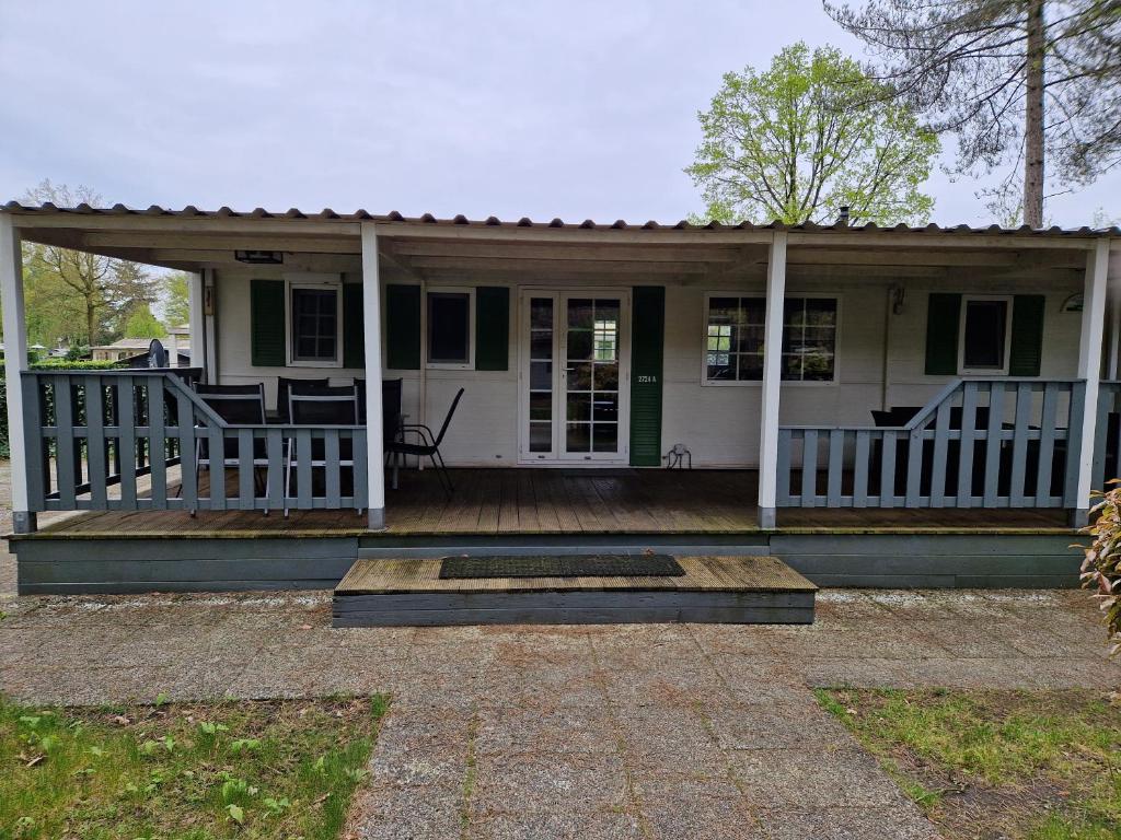 ein kleines weißes Haus mit einer Veranda und einer Veranda in der Unterkunft Breitner Chalet op de Schatberg in Sevenum