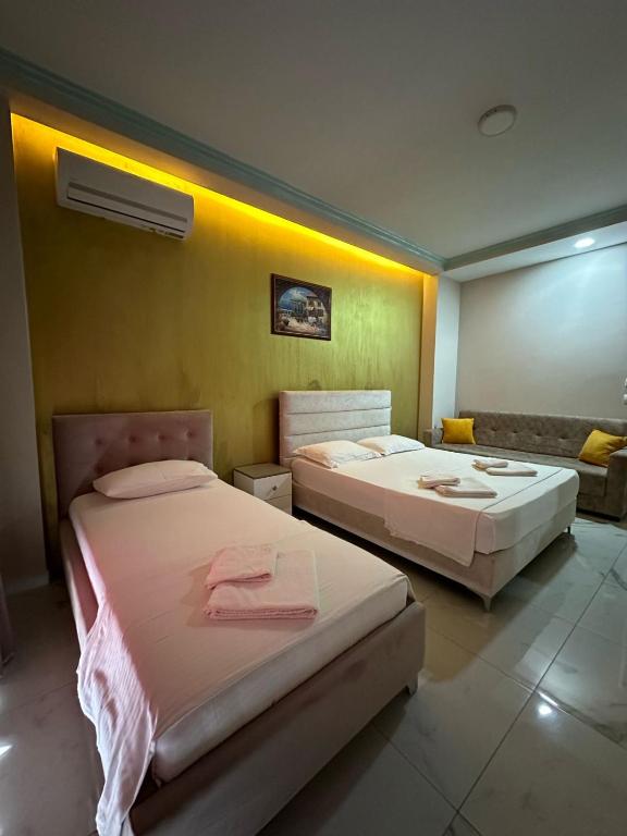 a room with two beds and a couch at Summer Gate Hotel in Ksamil