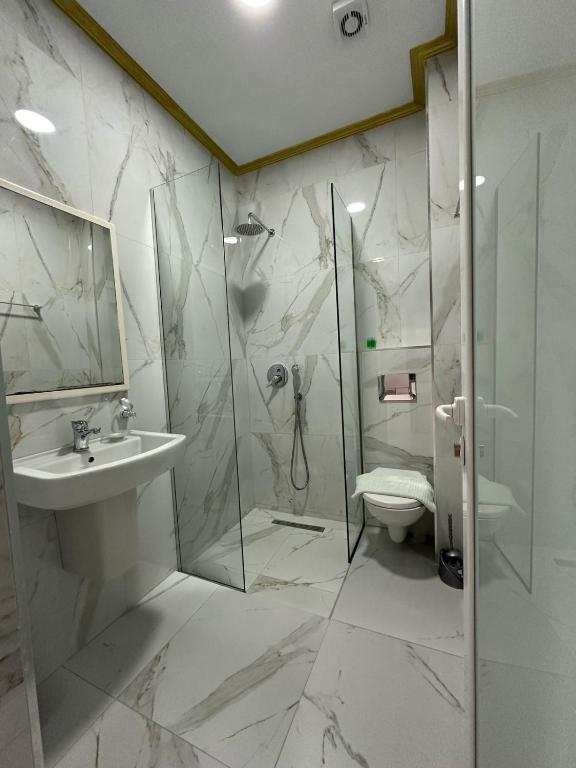 a bathroom with a shower and a sink and a toilet at Summer Gate Hotel in Ksamil