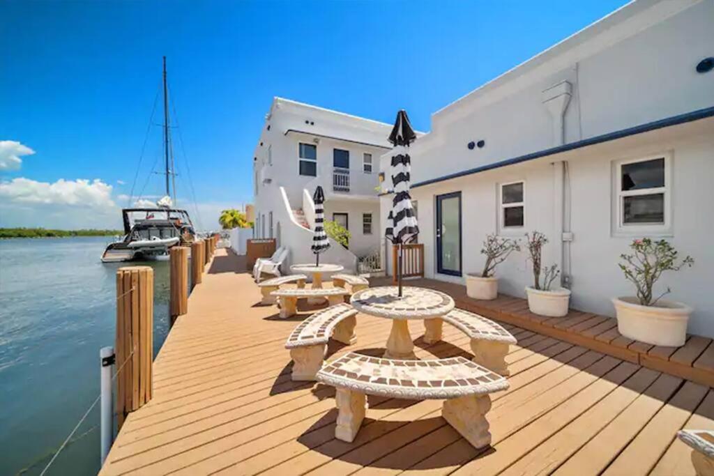 een houten terras met banken en tafels en een boot bij Komffy Waterside Escape w/Queen Bed & Free Parking in Hollywood
