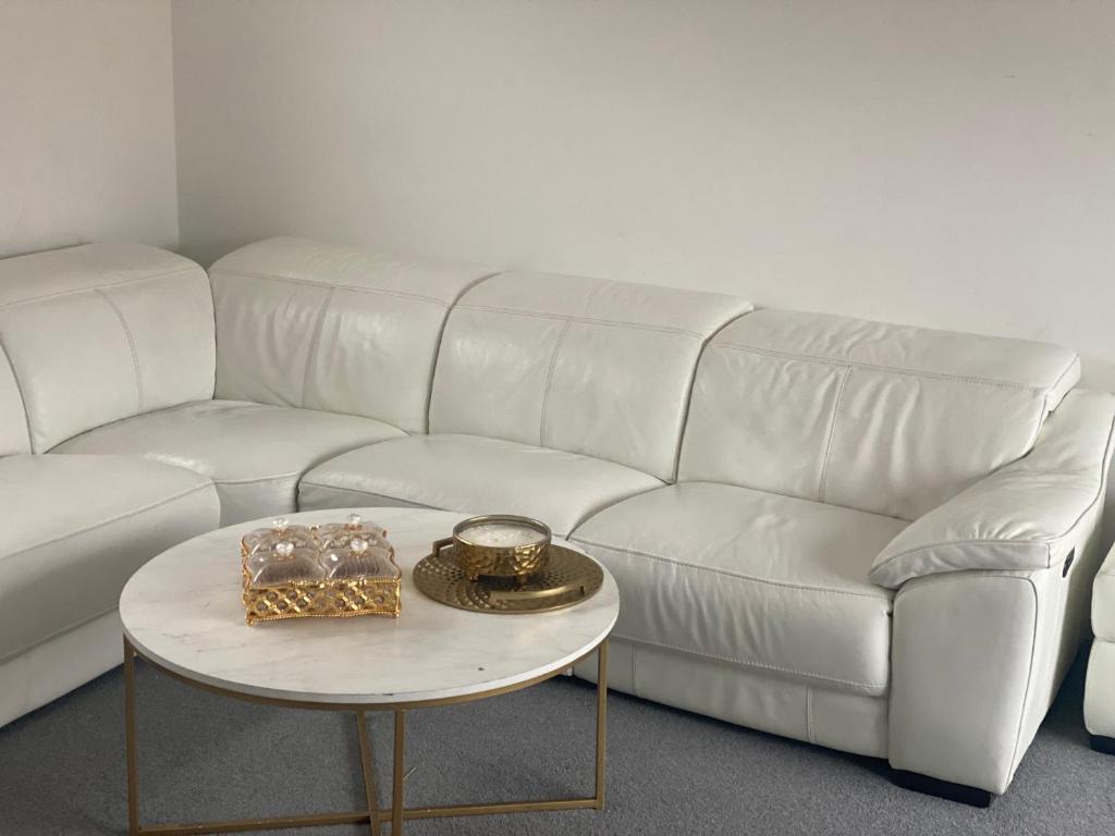 a white couch and a table with a tray on it at Stopin in Crawley